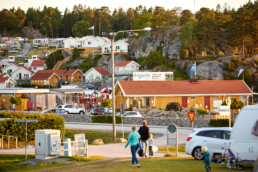 Personer på Lagunen med stugor i bakgrunden.